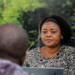 Rita Ngalula attending the meeting at Baobab RDC being conducted by David Muanda, CEO at Friendina College