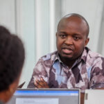 Arnold Elesse attending the meeting at Baobab RDC being conducted by David Muanda, CEO at Friendina College
